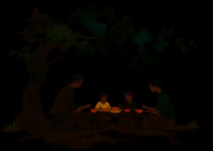 Famille partageant un repas en plein air sous un arbre